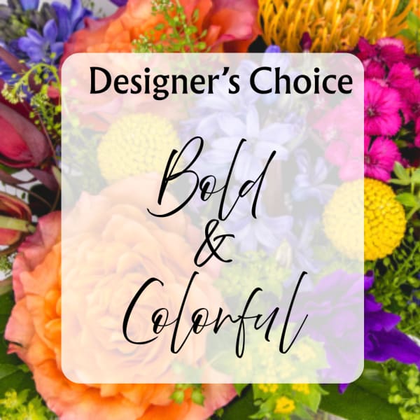 Colorful mixed flower arrangement with bold blooms and a "Designer’s Choice" sign