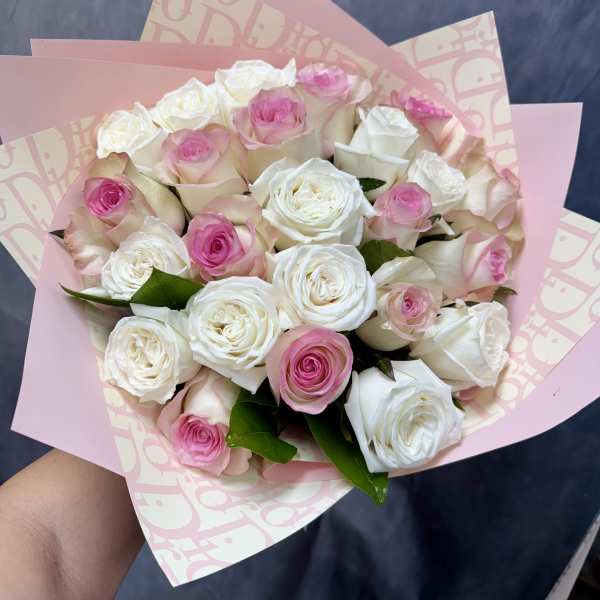 Bouquet of pink and white roses wrapped in pink paper