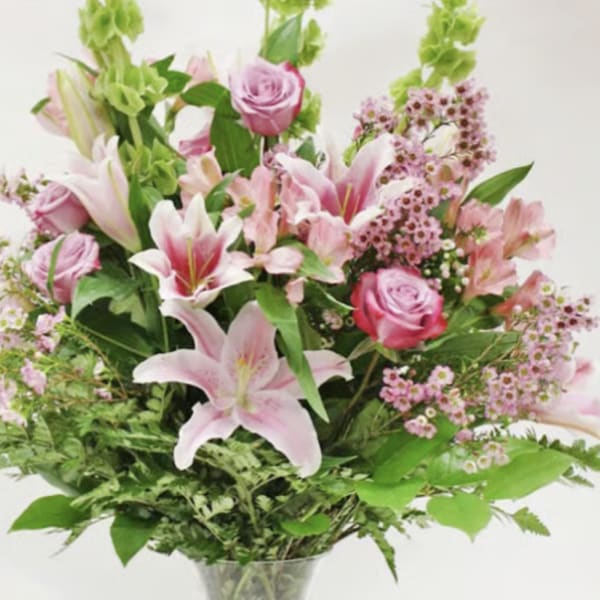 Pink lilies and roses in a clear vase