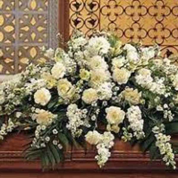 Large white floral casket spray with cascading blooms