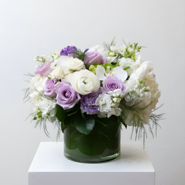 Lavender and white bouquet in a green glass vase