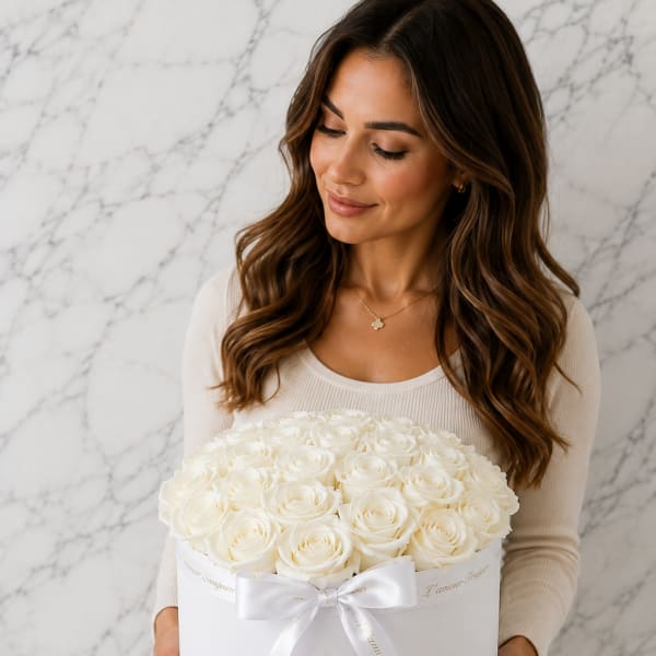 Woman holding a white hatbox of cream roses with a ribbon