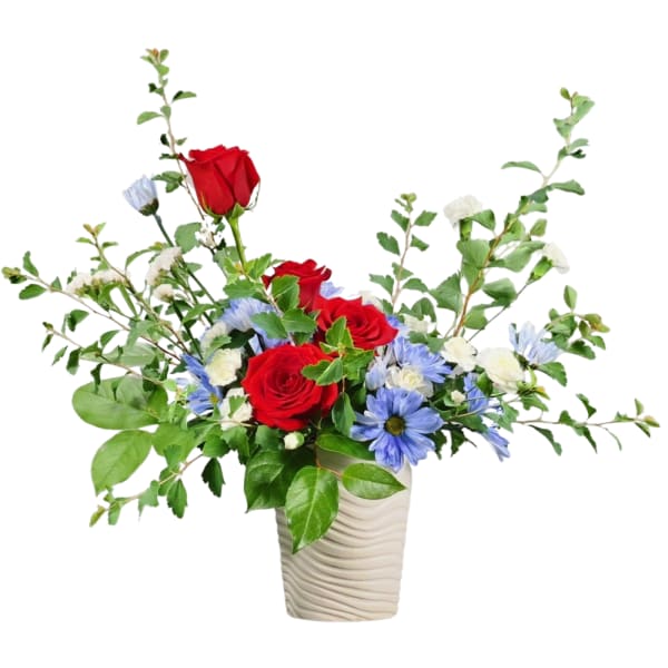 Red roses and blue daisies in a white vase
