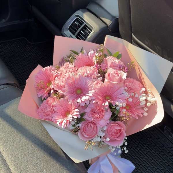 Pink bouquet with gerbera daisies and roses wrapped in pastel paper