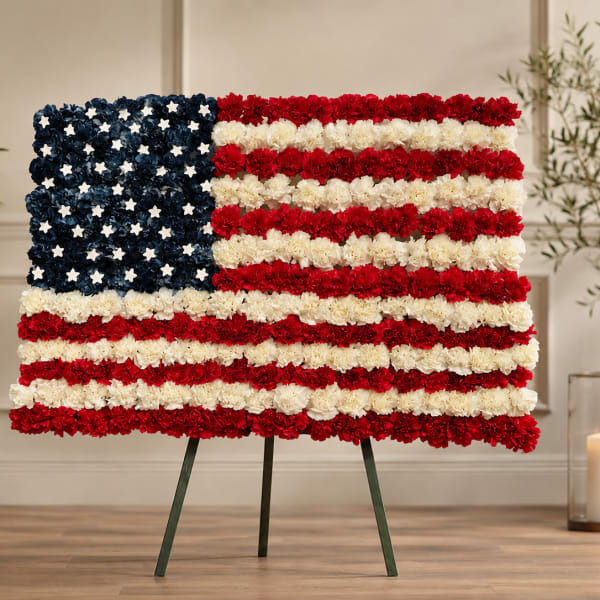 Floral arrangement shaped like the American flag on an easel
