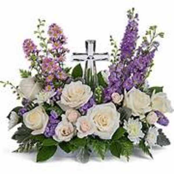 White and purple floral arrangement with a cross centerpiece
