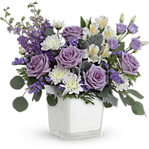 Lavender roses and white flowers in a white square vase