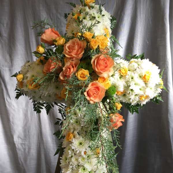 Cross-shaped floral arrangement with white daisies and peach roses