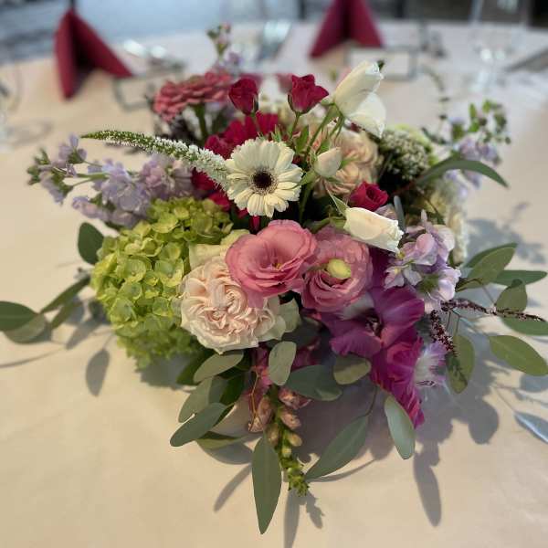 Colorful floral centerpiece with pink, white, and purple blooms on a table