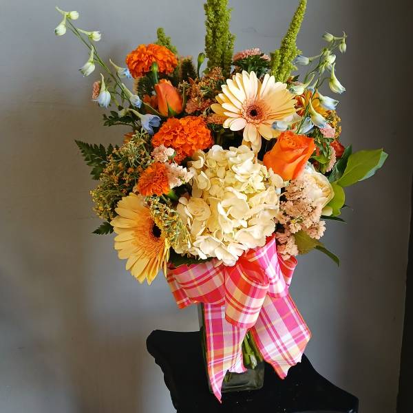 Mixed bouquet with orange and cream flowers in a glass vase