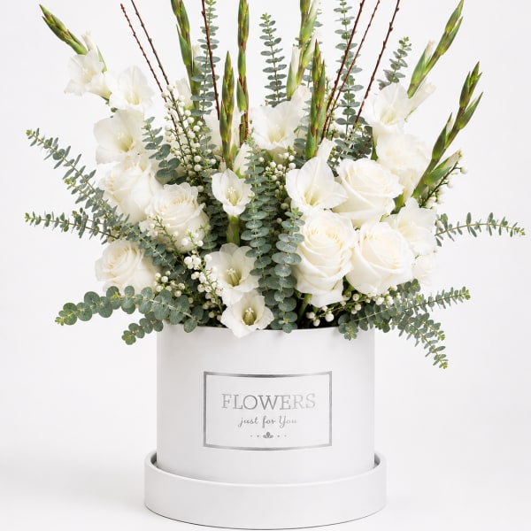 White roses and gladiolus in a white hatbox with eucalyptus