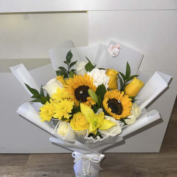 Beautiful and elegant arrangement with a glass base and mixed yellow flowers