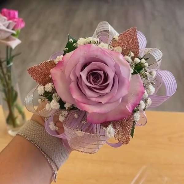 Pink rose corsage with ribbon loops and baby's breath