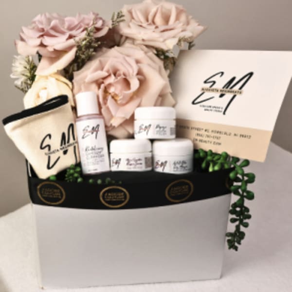 Gift box with pink roses, skincare items, and a card