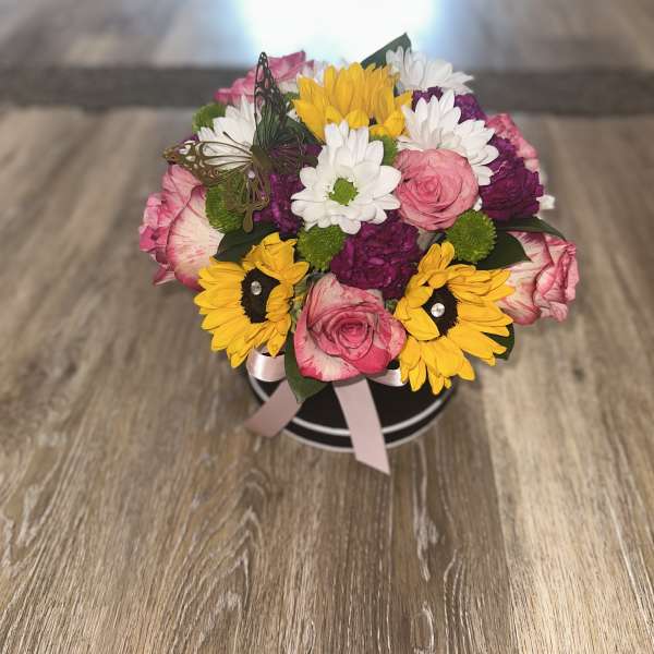 Mixed bouquet in a black round box with pink, yellow, white, and purple flowers