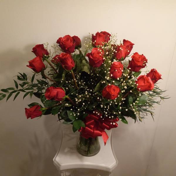 Bouquet of red roses with baby's breath in a glass vase
