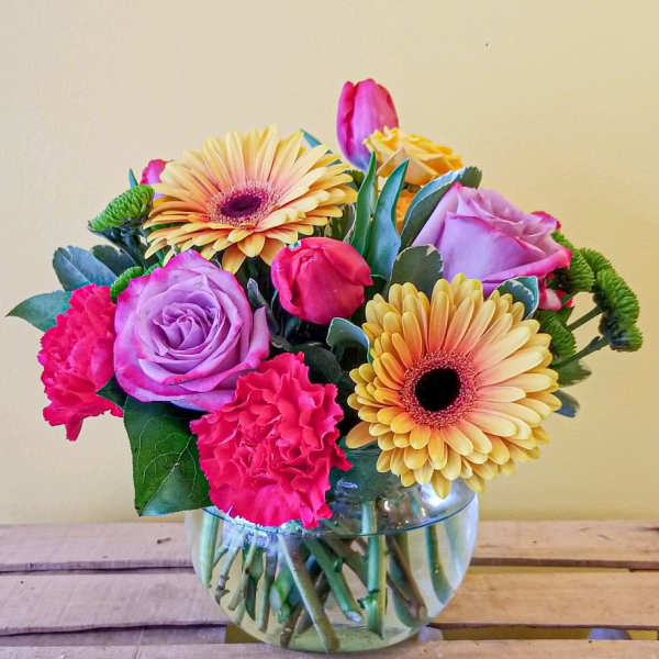 Mixed bouquet of pink and lavender flowers in a glass vase