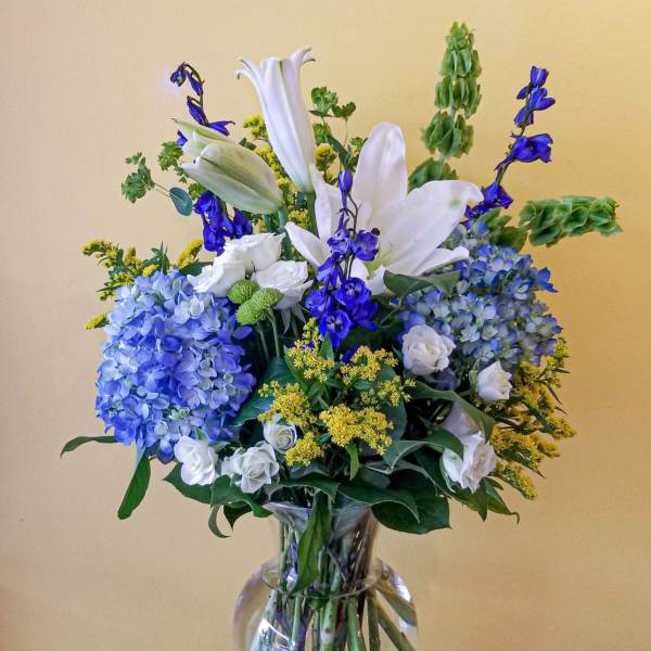 Blue and white flower arrangement in a clear glass vase