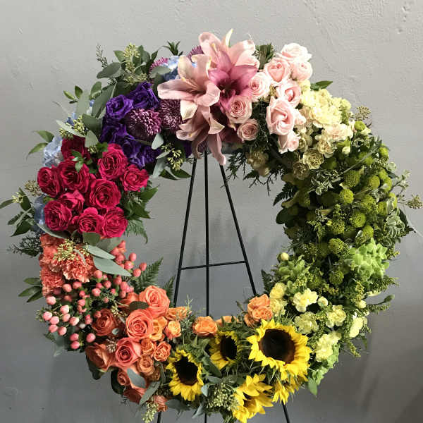 Large floral wreath on a black stand with multicolored blooms