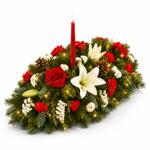 Holiday centerpiece with red and white flowers, pinecones, and a red candle