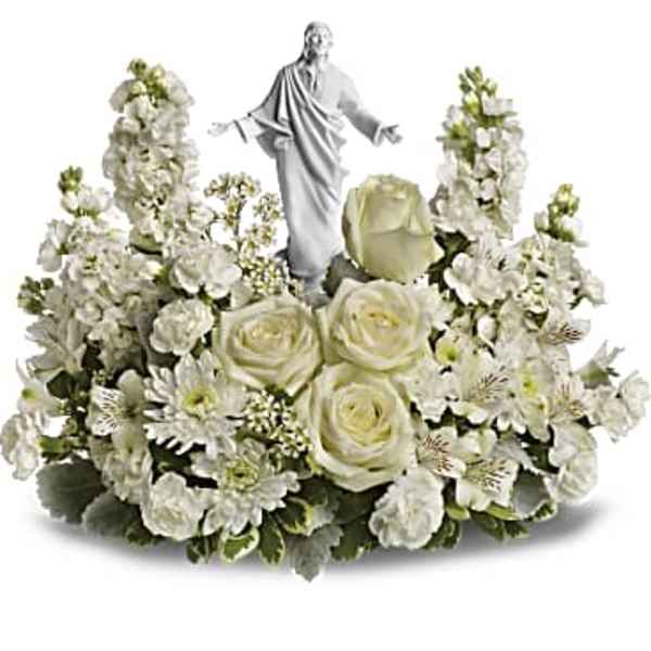 White floral arrangement with a small religious statue in the center
