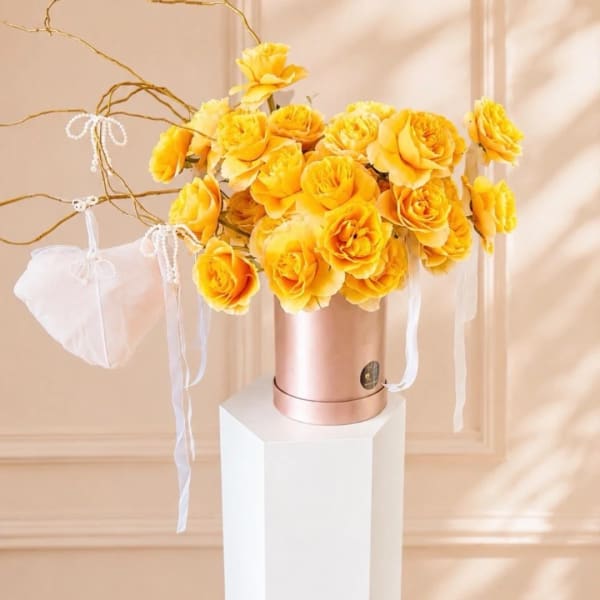 Yellow rose bouquet in a rose-gold box with white ribbons