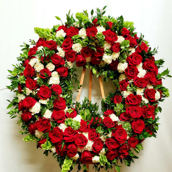 Large wreath of red roses and white carnations on a wooden easel