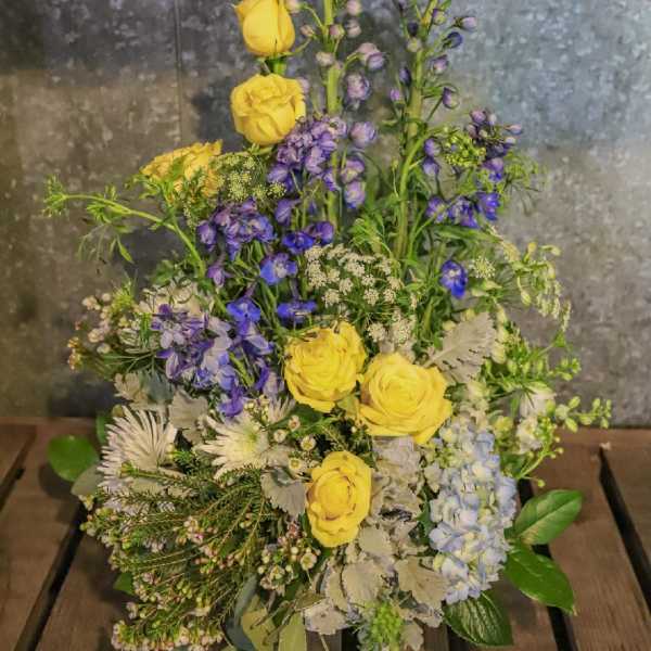 Yellow roses and blue-purple flowers in a mixed arrangement