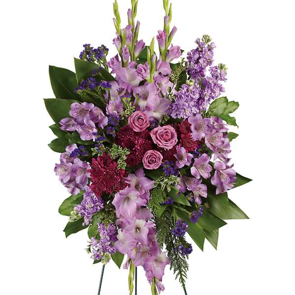Standing floral spray with purple blooms and pink roses on easel