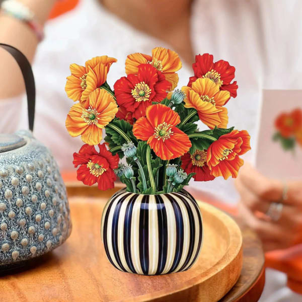Arrangement of red and orange flowers in a striped vase