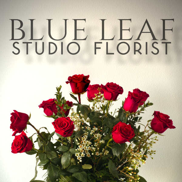 Red roses arranged in a clear glass vase