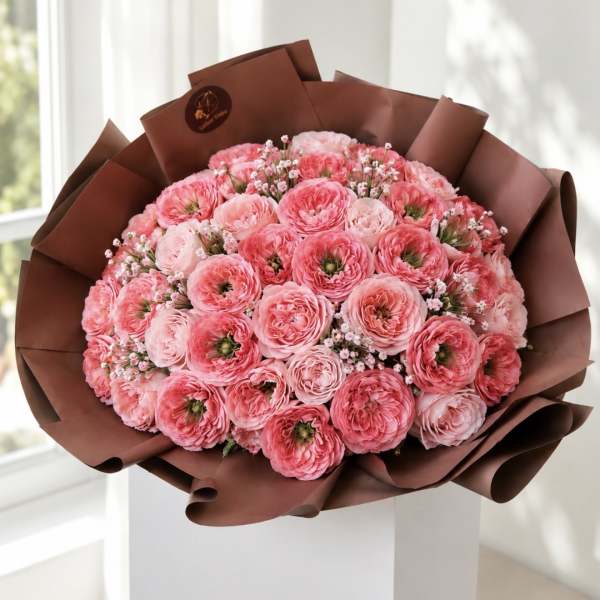 Bouquet of pink ranunculus wrapped in brown paper