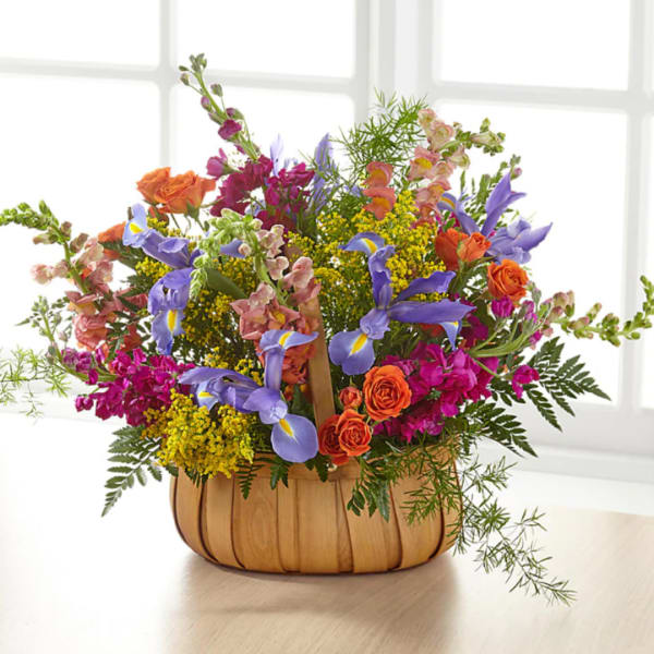 Colorful mixed flower arrangement in a woven basket