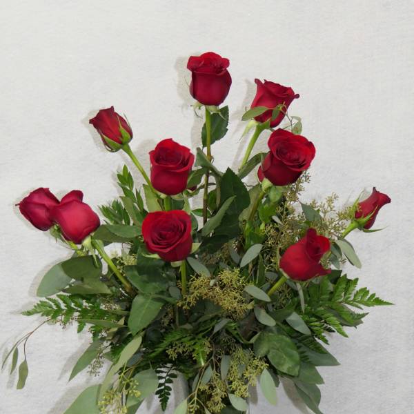 Red roses arranged in a clear glass vase