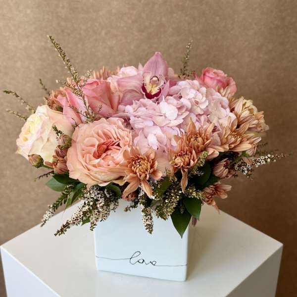 Pink and peach bouquet in a white box vase