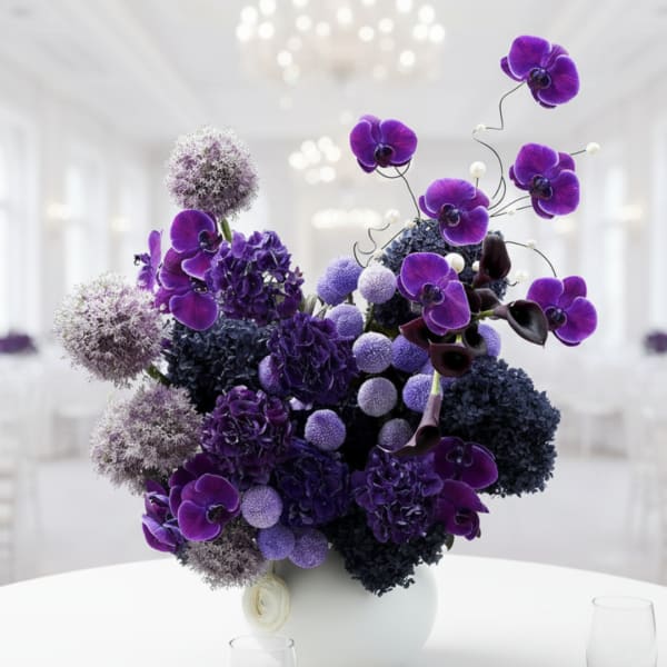 Purple orchid arrangement in a white vase