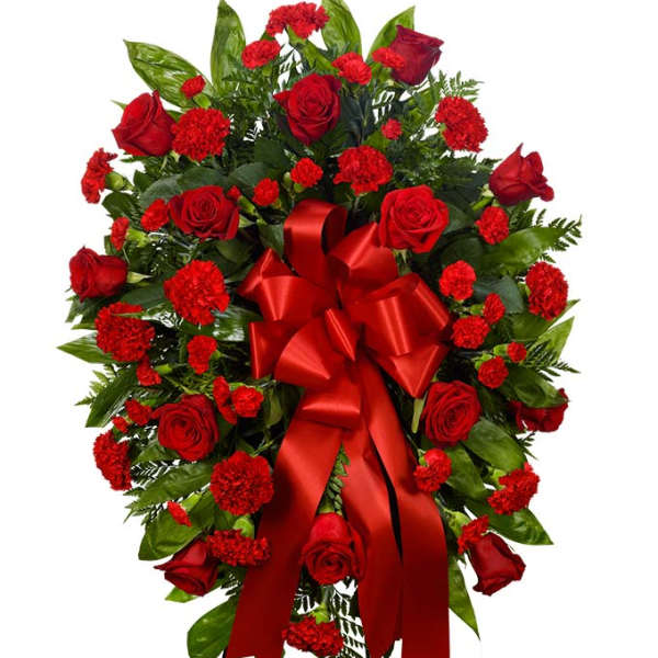Red rose and carnation standing spray with a red ribbon bow