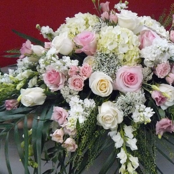 Large pink and white floral spray with a ribbon on a red background