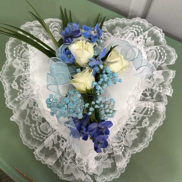 Heart-shaped bouquet of white roses and blue flowers with lace trim
