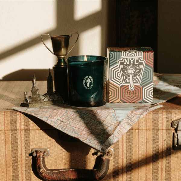 Candle, trophy, and decorative box on a suitcase with a map cloth