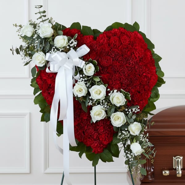 Heart-shaped red floral funeral spray with white roses and ribbon