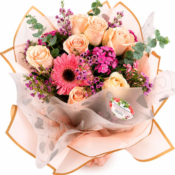 Bouquet of peach roses and pink gerbera daisies wrapped in pale peach paper