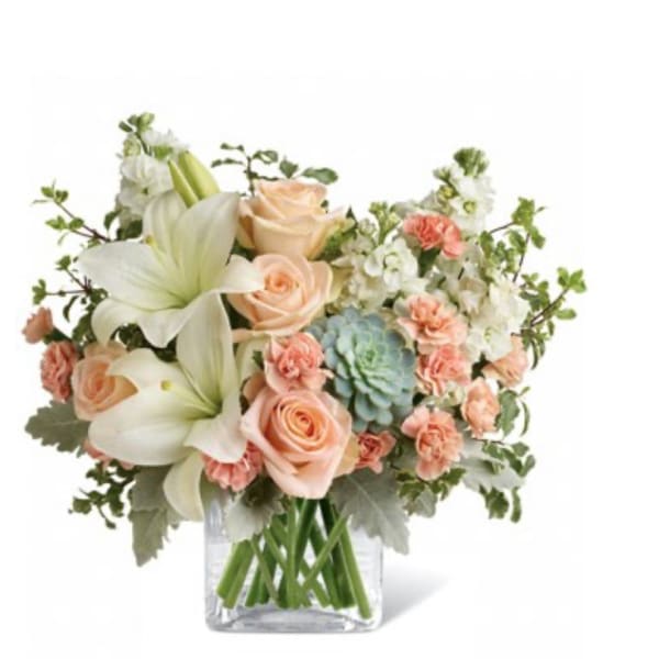 Bouquet of peach roses and white lilies in a clear glass vase