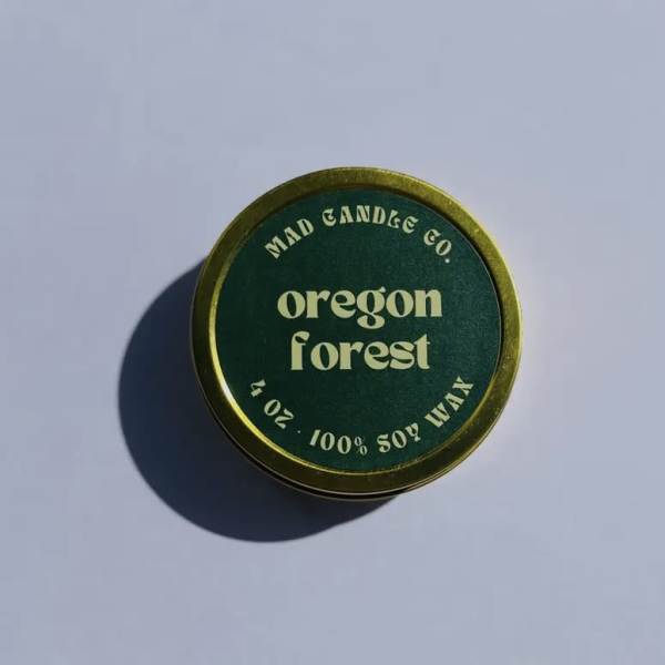 Round green candle tin labeled Oregon Forest