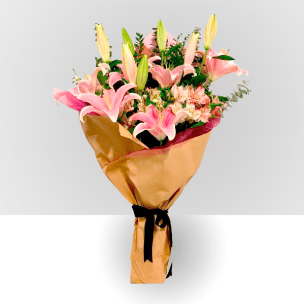 Bouquet of pink lilies and mixed flowers wrapped in gold paper