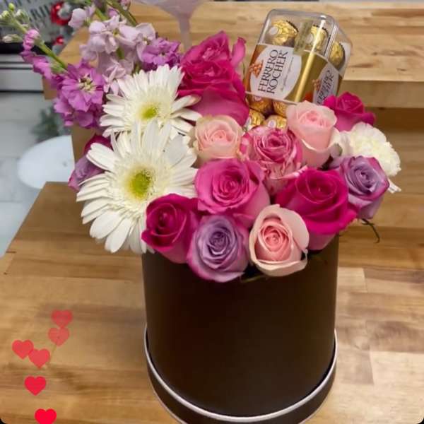 Flower arrangement with a clear balloon reading "I Love You MOM" and chocolates