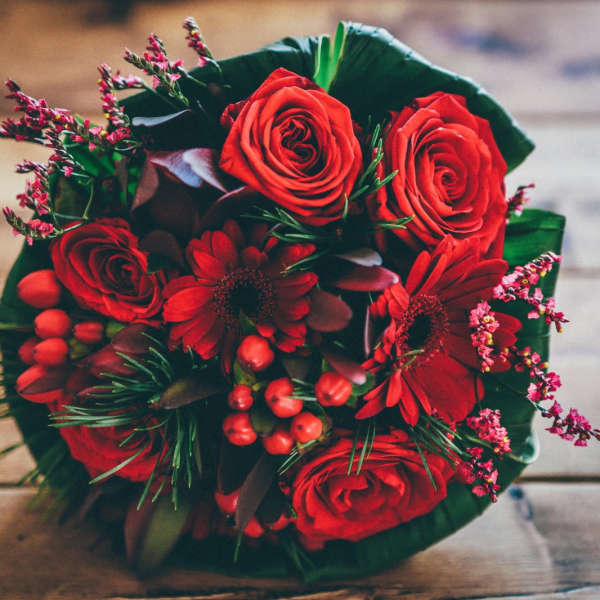 Red rose bouquet with red daisies and berry accents
