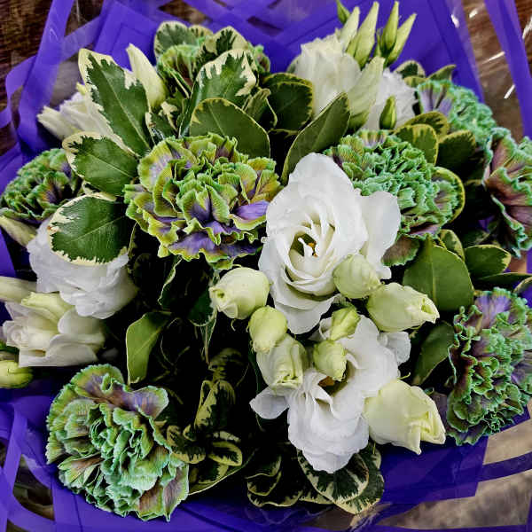 Bouquet of white lisianthus and green-purple carnations wrapped in purple paper