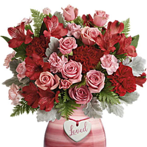 Pink and red rose bouquet in a pink vase with a heart tag