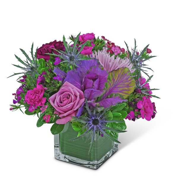 Pink and purple bouquet in a square glass vase